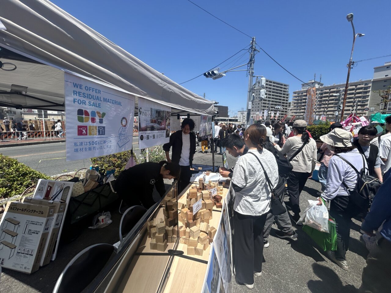 東大阪市民ふれあい祭りで来場者がイニハンスブースの木材アイテムを見ている様子