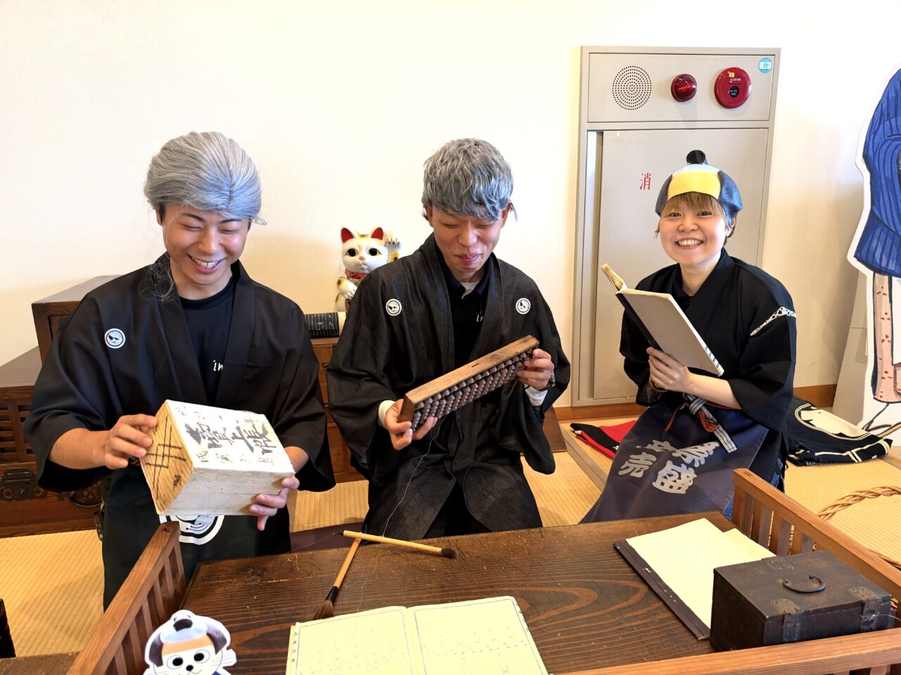 近江商人の衣装や商いの道具に触れるイニハンスのスタッフ