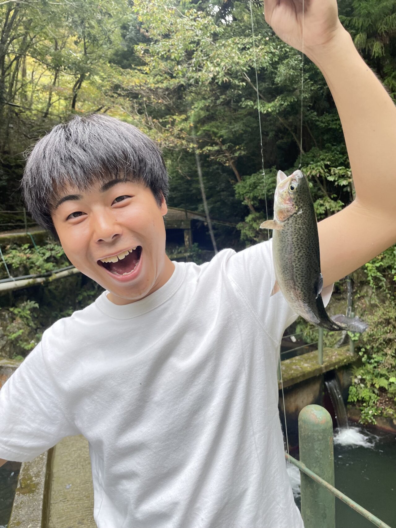 釣り上げたマスを掲げて喜ぶイニハンスのスタッフ